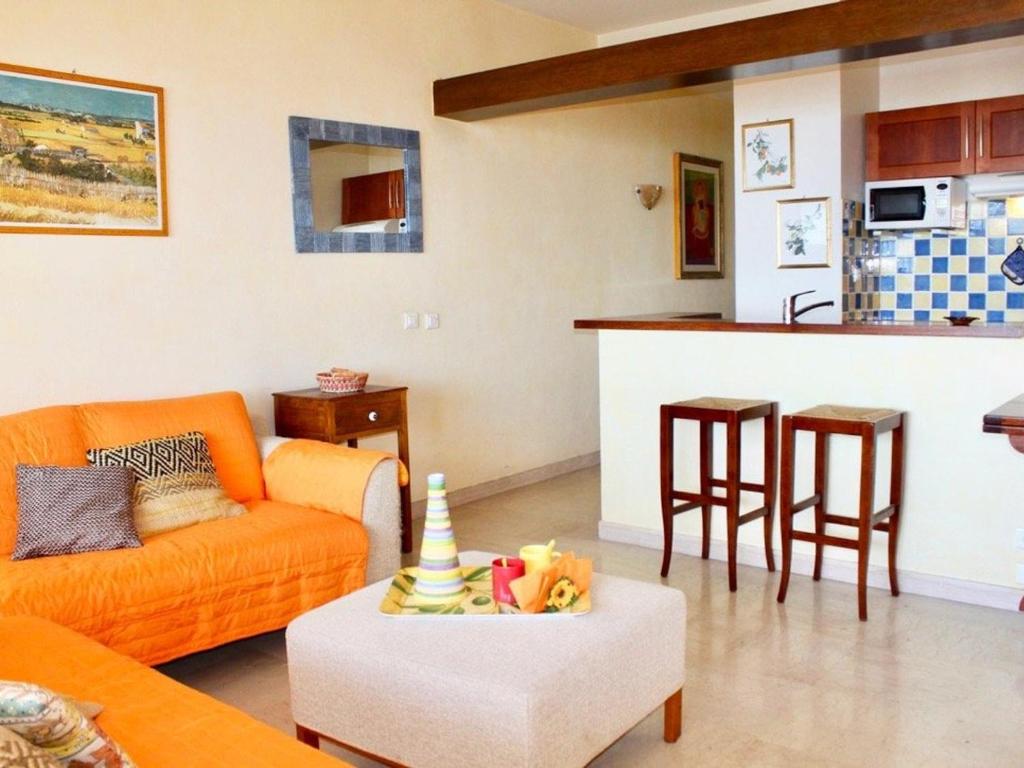 un salon avec un canapé orange et une cuisine dans l'établissement Splendide T2 avec terrasse et garage, à 3 min de la plage, 4 couchages - FR-1-252A-120, à Villeneuve-Loubet