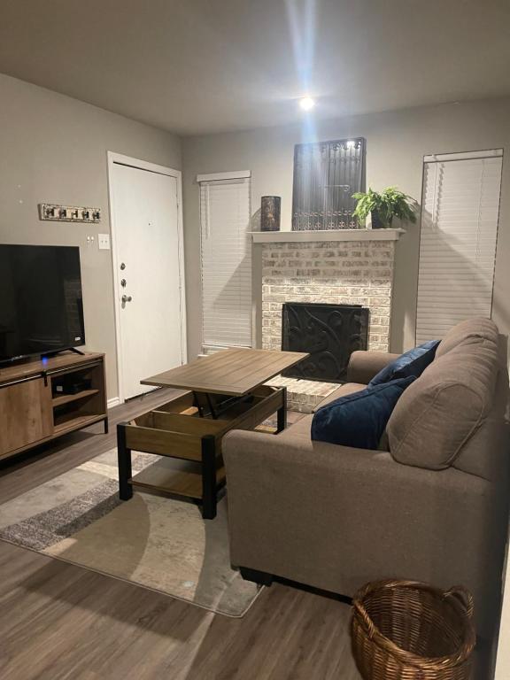ein Wohnzimmer mit einem Sofa, einem Tisch und einem Kamin in der Unterkunft Apartment in Dallas