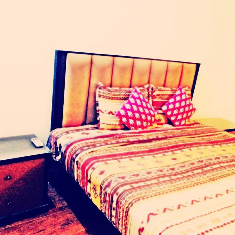una camera da letto con un letto con cuscini sopra di Couples Heaven Apartment a Lahore
