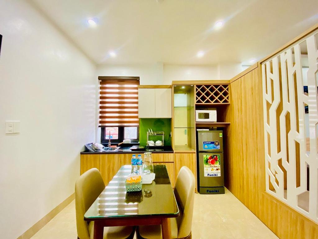 a kitchen with a table and chairs and a refrigerator at PHƯƠNG DONG HOTEL in Ðông Khê