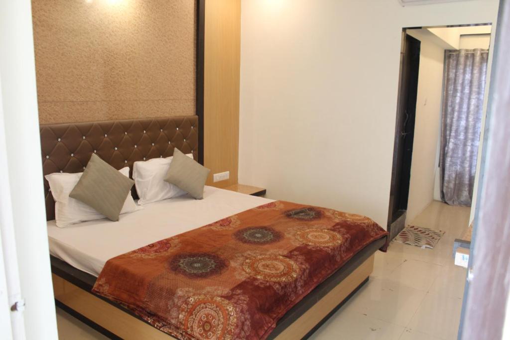 sypialnia z łóżkiem z brązowym zagłówkiem w obiekcie Hotel Skylark w mieście Vapi