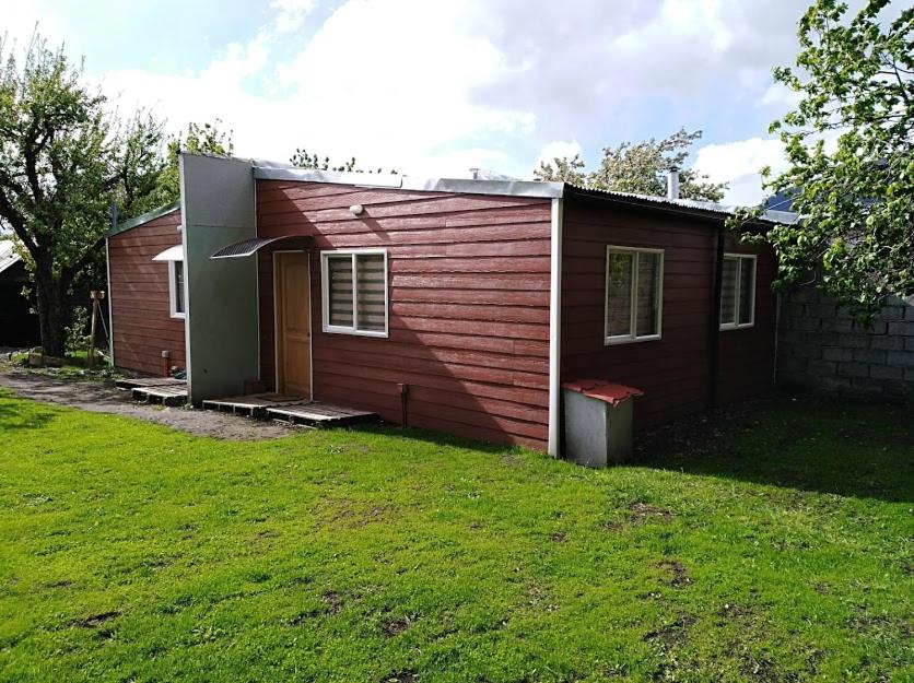 a small house with a grass yard in front of it at CABAÑAS TRAPAGONIA in Coihaique