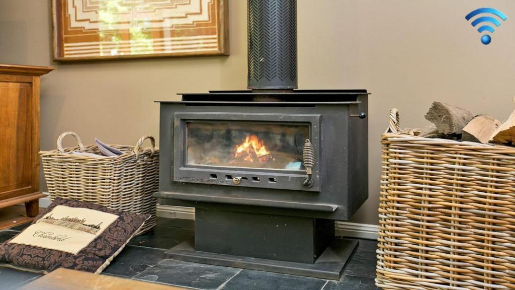 a fireplace in a living room with two baskets at Sinden Park in Exeter