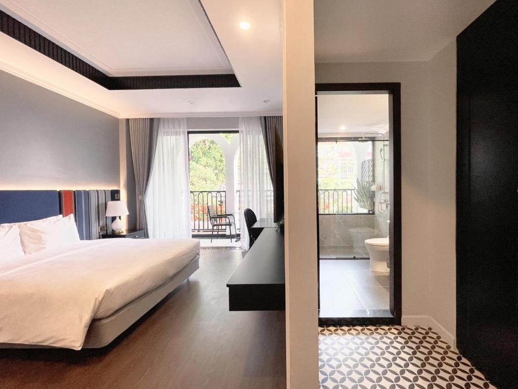 a bedroom with a bed and a view of a bathroom at Indigo Boutique Hotel in Cao Bằng