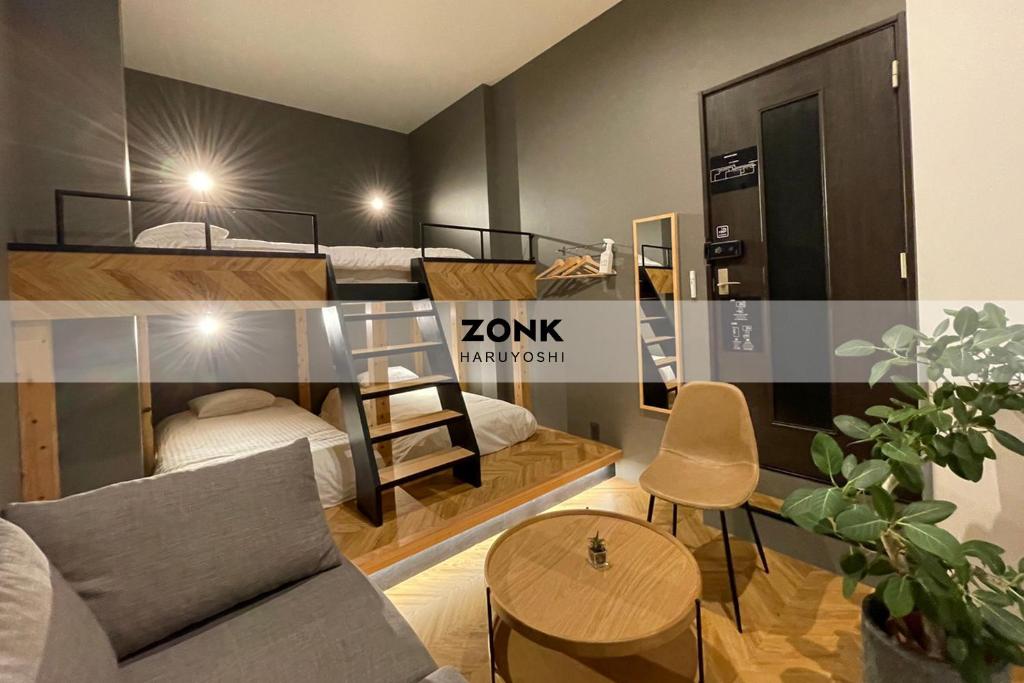 福岡市にあるゾンクホテル春吉の二段ベッド2台とソファが備わる客室です。