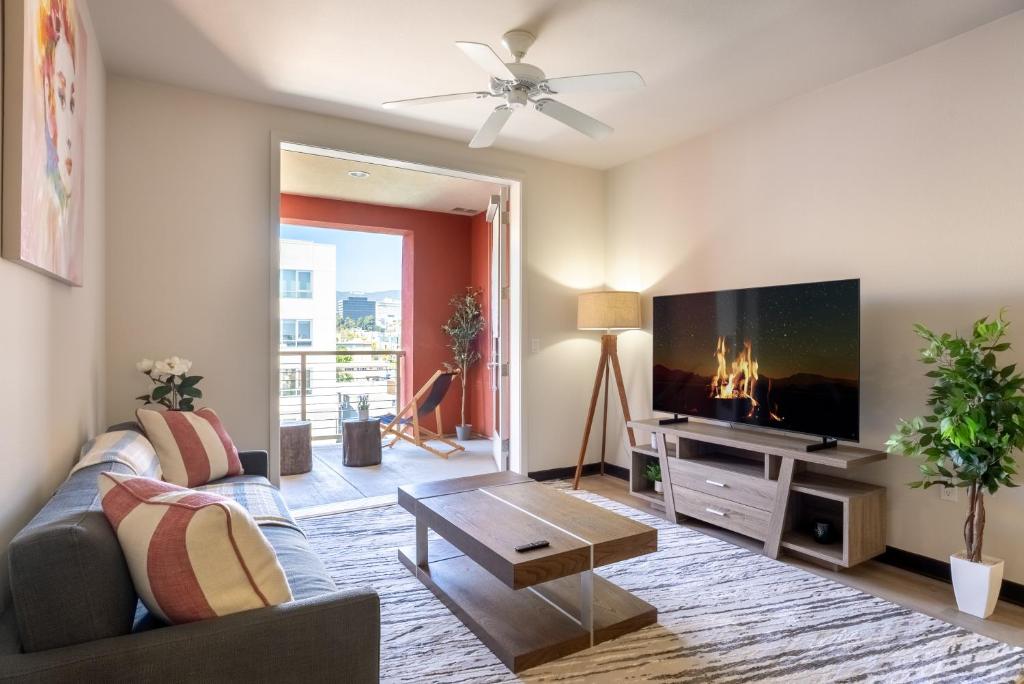 a living room with a couch and a flat screen tv at Charming Luxury Apartment with Hollywood Sign View in Los Angeles