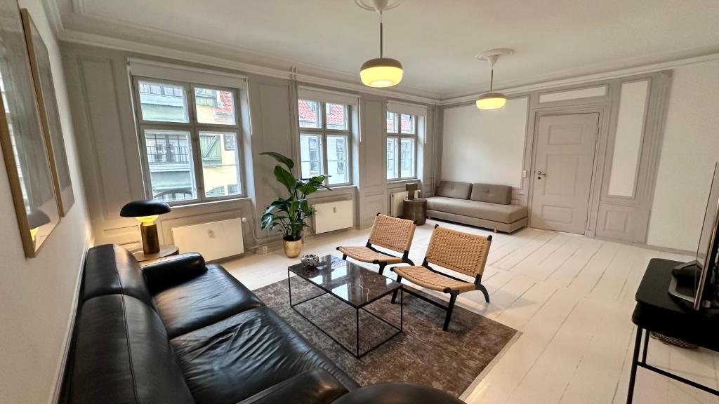 a living room with a leather couch and chairs at The Admirals Apartments - Carolinas apartments in Copenhagen