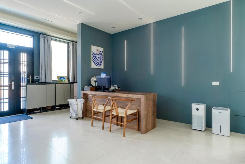 a blue room with two chairs and a desk at 澎湖笑掌家 in Magong