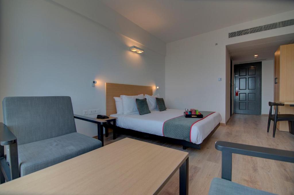 清奈的住宿－ARN RESIDENCY，配有一张床和一把椅子的酒店客房