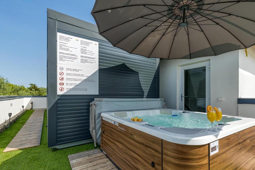 bañera de hidromasaje con sombrilla en la cubierta en Rooftop Home With Whirlpool & Sauna en Trebnje