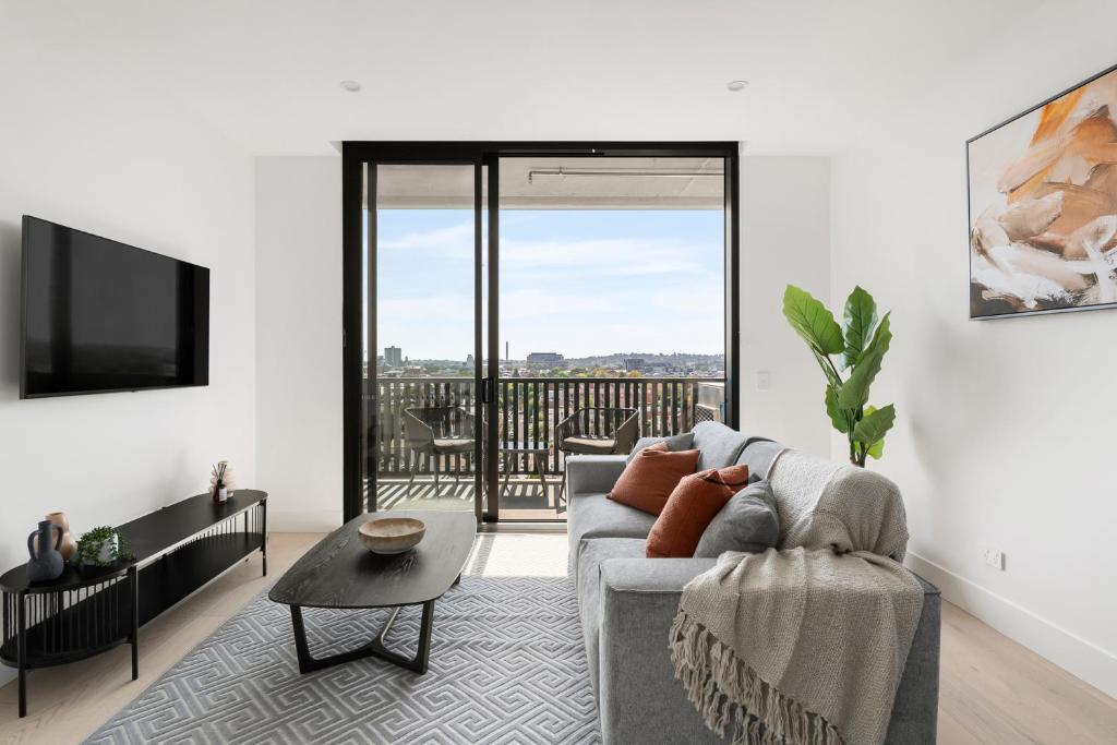 sala de estar con sofá y TV en Urban Rest Richmond Apartments en Melbourne