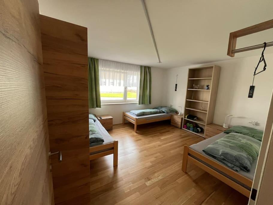 a room with two beds and a living room with at Meranerhof in Julbach