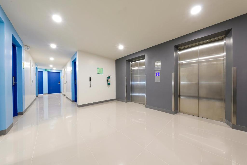 un pasillo vacío con ascensores en un edificio en Hop Inn Hotel North EDSA Quezon City, en Manila