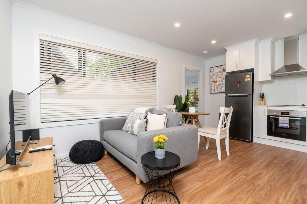 a living room with a gray couch and a table at Cosy 1 BR unit in Ainslie in Canberra