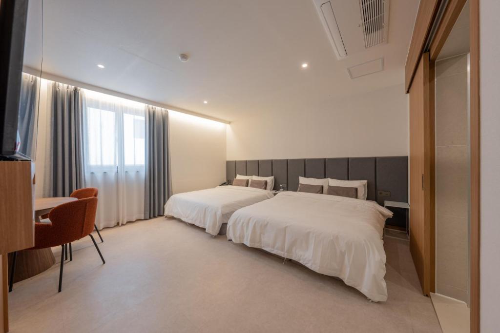 Postel nebo postele na pokoji v ubytování H-avenue Hotel Munhyeon