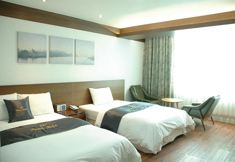 GoseongにあるPrince hotelのベッド2台と窓が備わるホテルルームです。