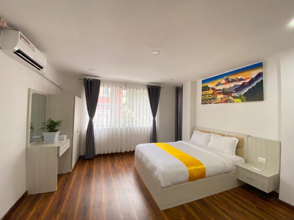Habitación de hotel con cama y ventana en Himalayan laligurans Hospitality, en Katmandú