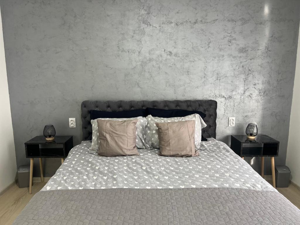 ein Schlafzimmer mit einem großen Bett mit zwei Nachttischen in der Unterkunft Apartman Central Lux A&D in Bečej