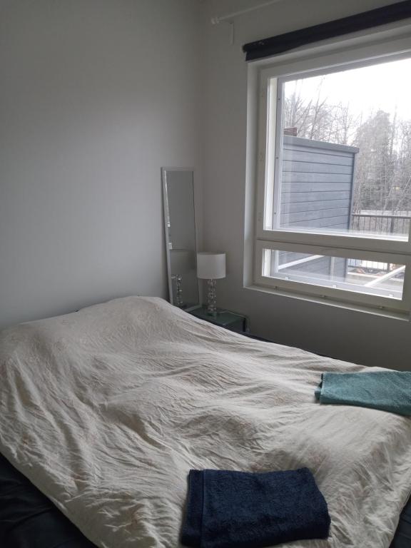 a bed with two towels on it in a room with a window at Cozy and peaceful Dublex in Espoo