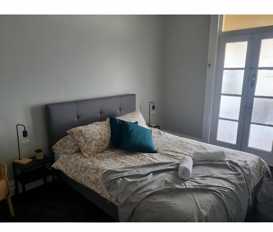 - une chambre avec un lit et des oreillers bleus dans l'établissement Commercial Hotel Young, à Young