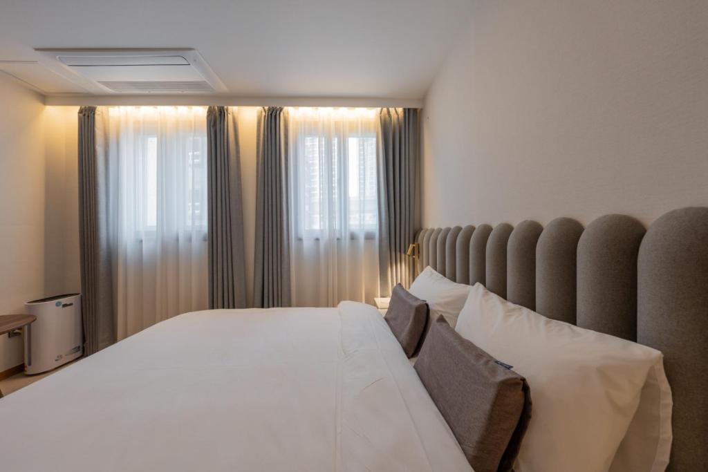 Postel nebo postele na pokoji v ubytování H-avenue Hotel Munhyeon