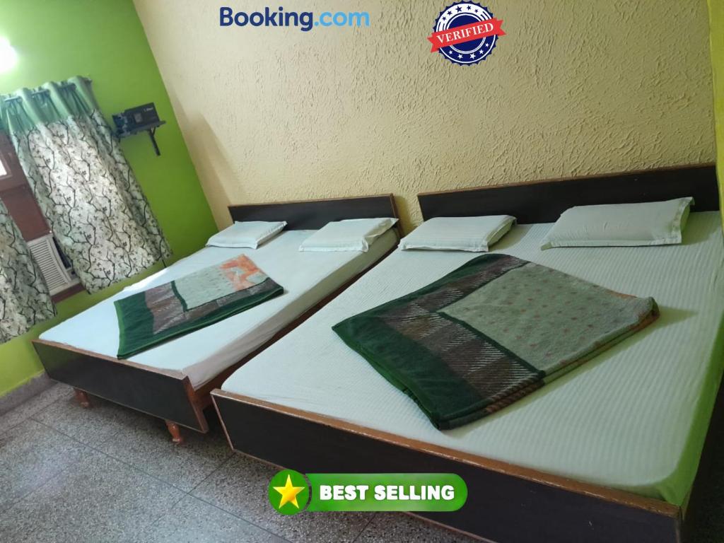 two beds sitting next to each other in a bedroom at Hotel Gayatri Guest House Haridwar Near Railway Station - Ganga Ghat - Best Hotel in Haridwar in Haridwār