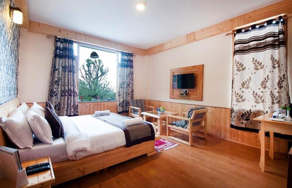 - une chambre avec un lit, un bureau et une fenêtre dans l'établissement Sethan valley cottage, à Manali