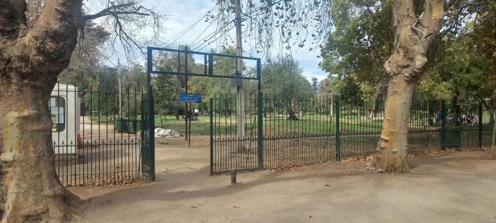 a gate in a park next to a tree at Movistar Apart Santiago in Santiago