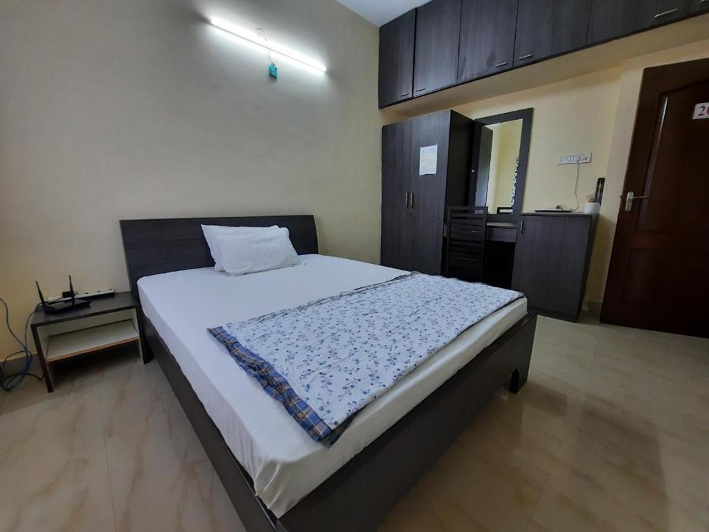 1 dormitorio con 1 cama grande con sábanas blancas en 소문난게스트하우스, en Kanchipuram