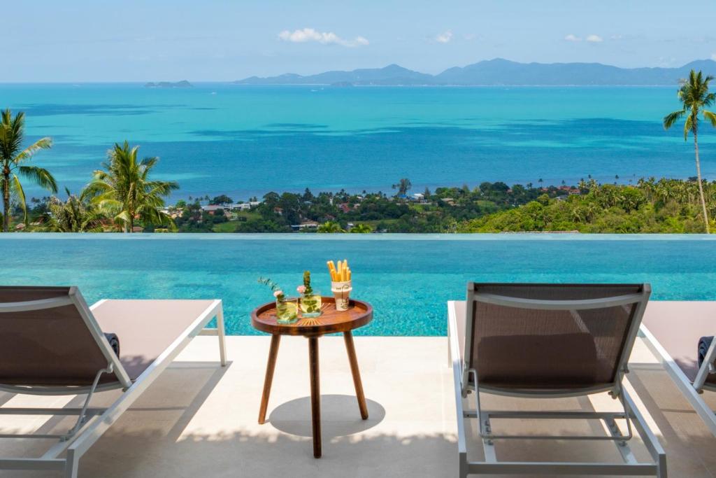 un patio con tavolo, 2 sedie e vista sull'oceano di Bohemian Chic Seaview Villa a Ko Samui