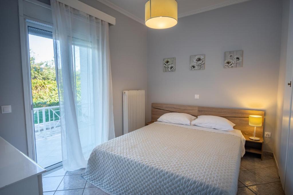 a bedroom with a bed and a large window at Stefano's Home in Potokáki