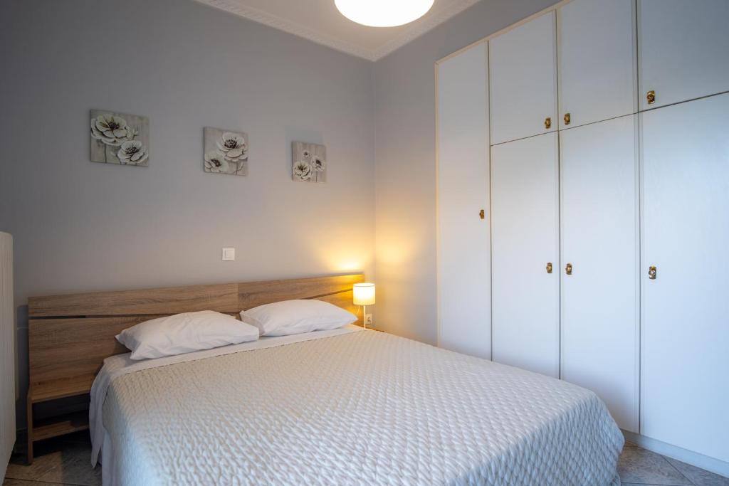 a white bedroom with a bed and white cabinets at Stefano's Home in Potokáki