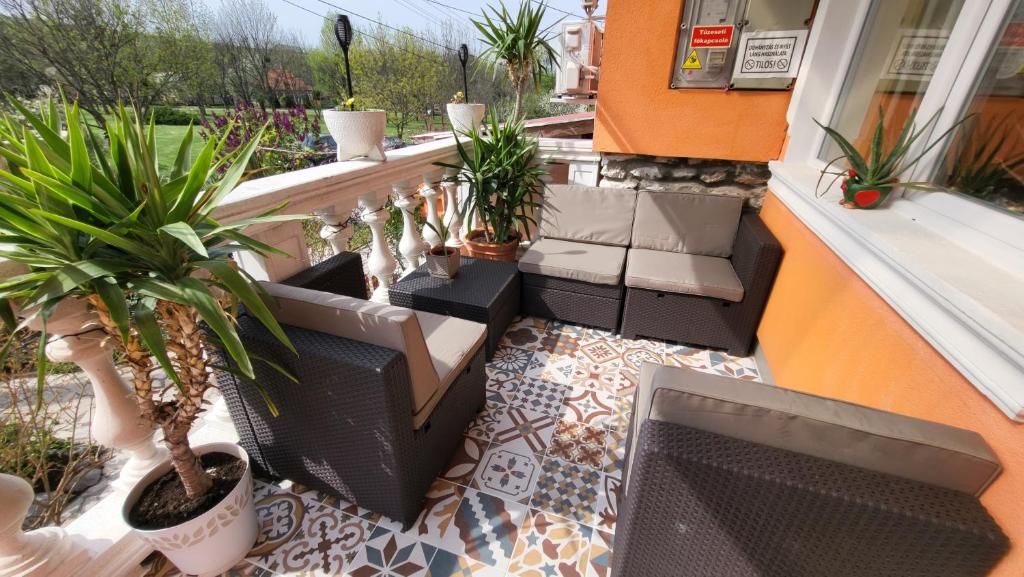 un patio con piante in vaso sul balcone di Liget Nyaralóház és Apartman Liget a Szilvásvárad