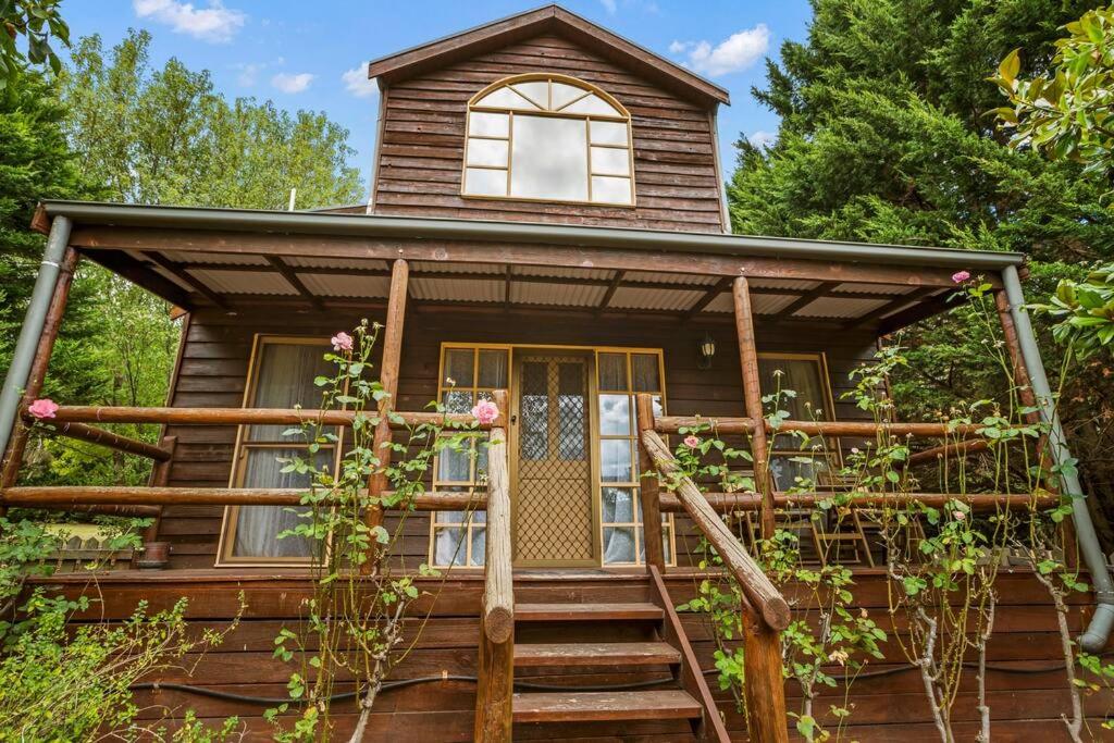 een tiny house met een trap naar de voordeur bij StayAU The Loft 1BR Rustic Picturesque Cottage in Badger Creek