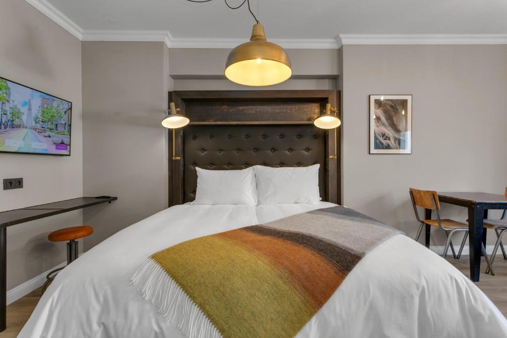 Postel nebo postele na pokoji v ubytování ODDSSON Downtown Hotel