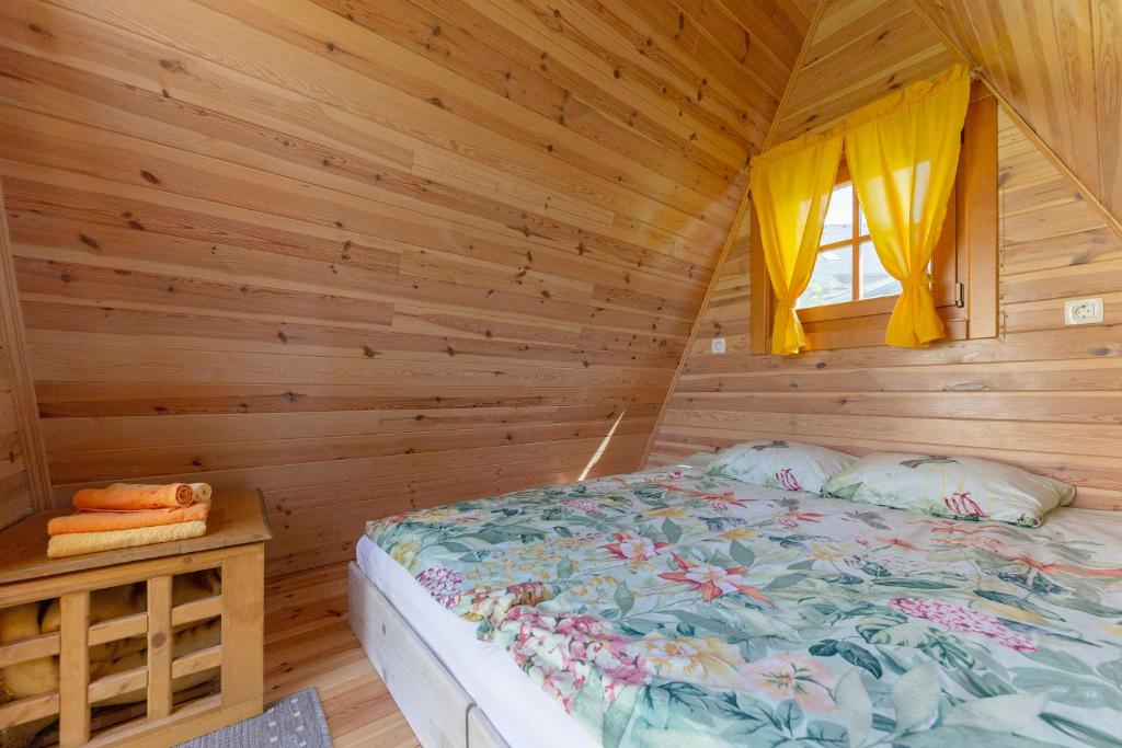 a bedroom with a bed in a wooden cabin at Glamping Mohorjev grunt in Preddvor