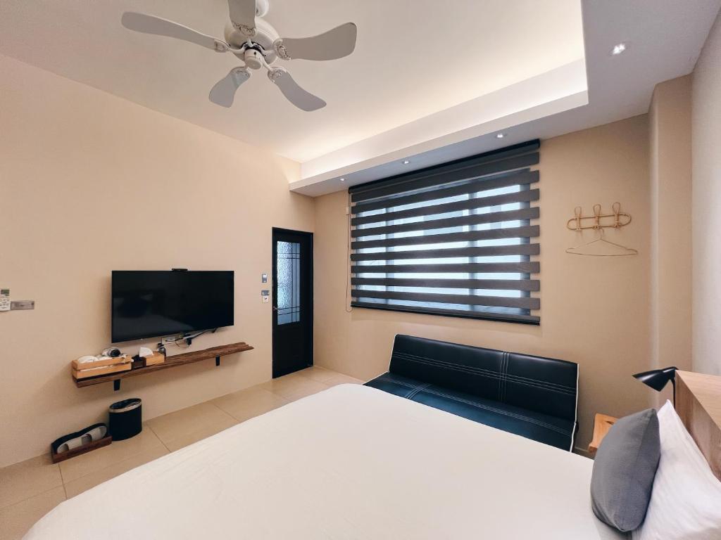 a bedroom with a large bed and a flat screen tv at Qixingtan Xinghai B&amp;B in Dahan