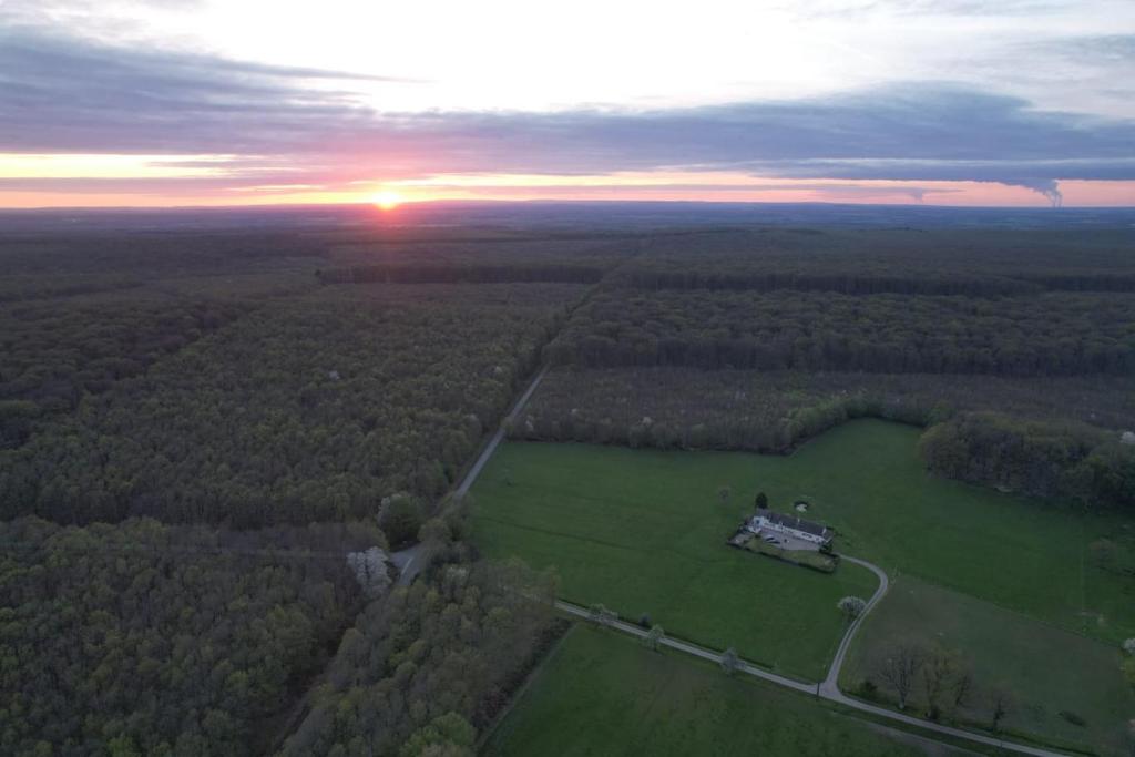 une vue aérienne sur une maison dans un champ au coucher du soleil dans l'établissement Longère au cœur des Bertranges, à Saint-Aubin-les-Forges