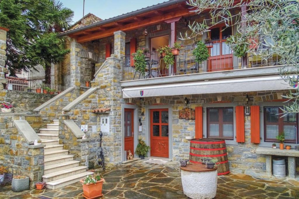 a stone house with a red door and stairs at Tourist Farm Tonin - Apartments - Happy Rentals in Šmarje