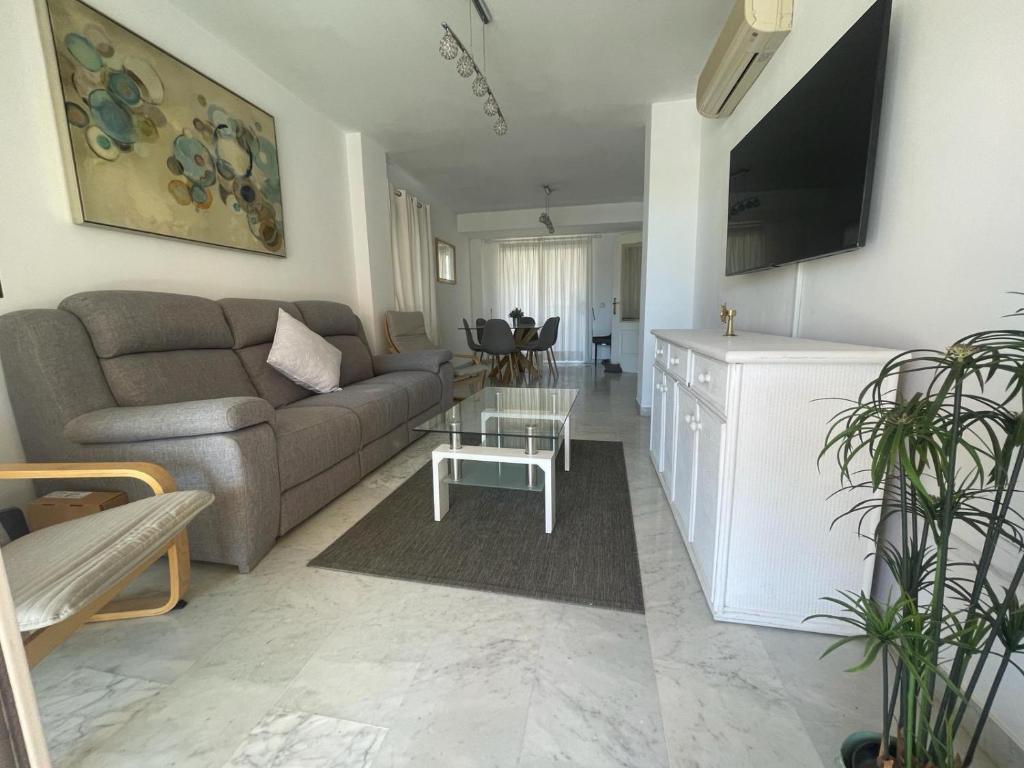 uma sala de estar com um sofá e uma mesa em Spacious & bright apartment em Aduanas