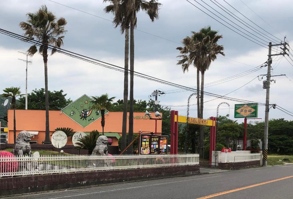 um parque de diversões com palmeiras e um edifício em 夢街道53 em Okayama