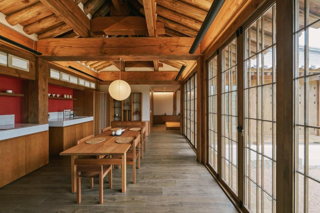 cocina y comedor con techos de madera y ventanas grandes en Muuun, en Gyeongju