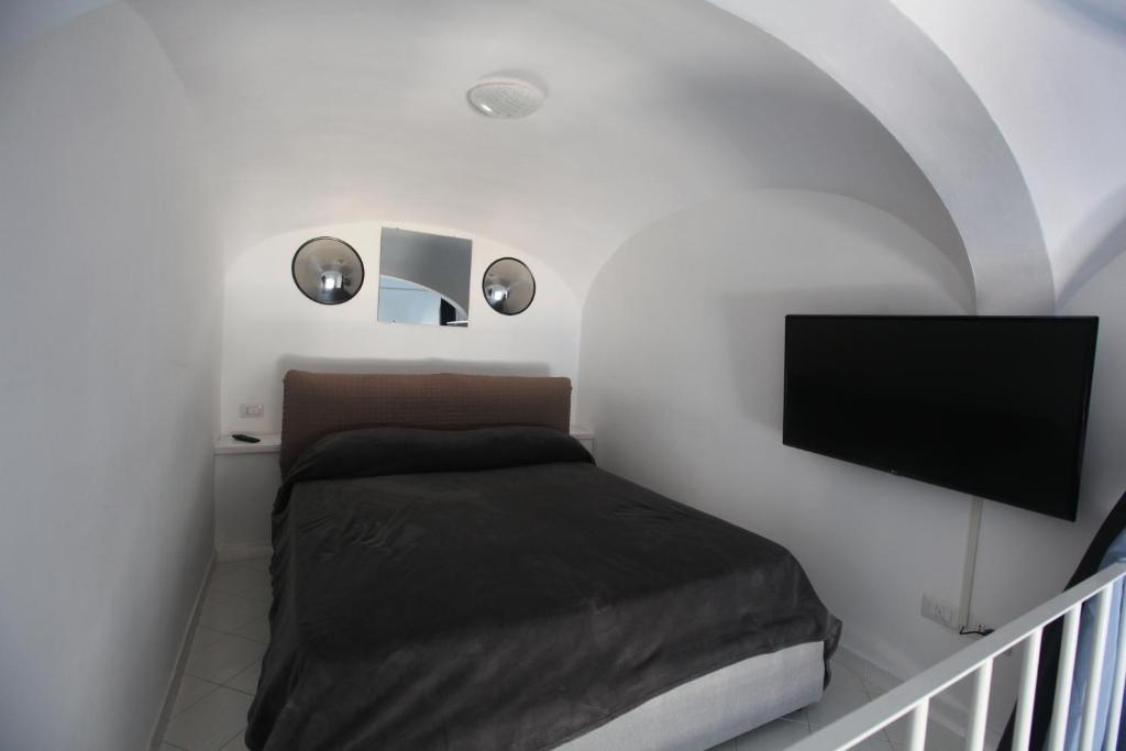 a bedroom with a bed and a flat screen tv at Rd Guest house in Ischia