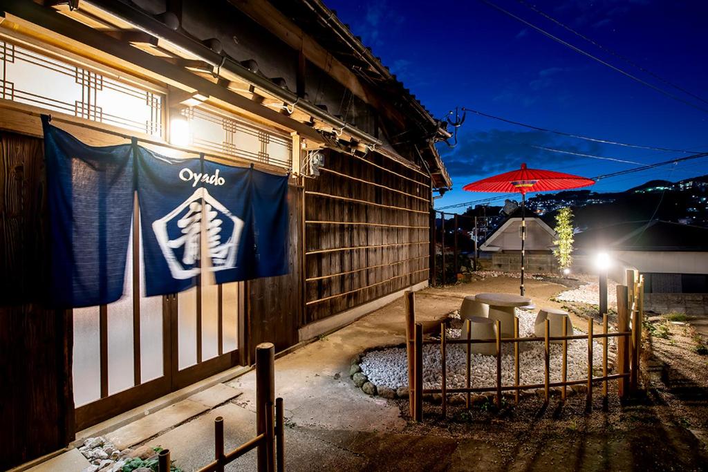 un cartello sul lato di un edificio con un ombrello di 【Oyado龍】檜の露天風呂付 和モダンな古民家115㎡貸し切りの宿 1日1組限定【8名宿泊可能】 a Asahimachi