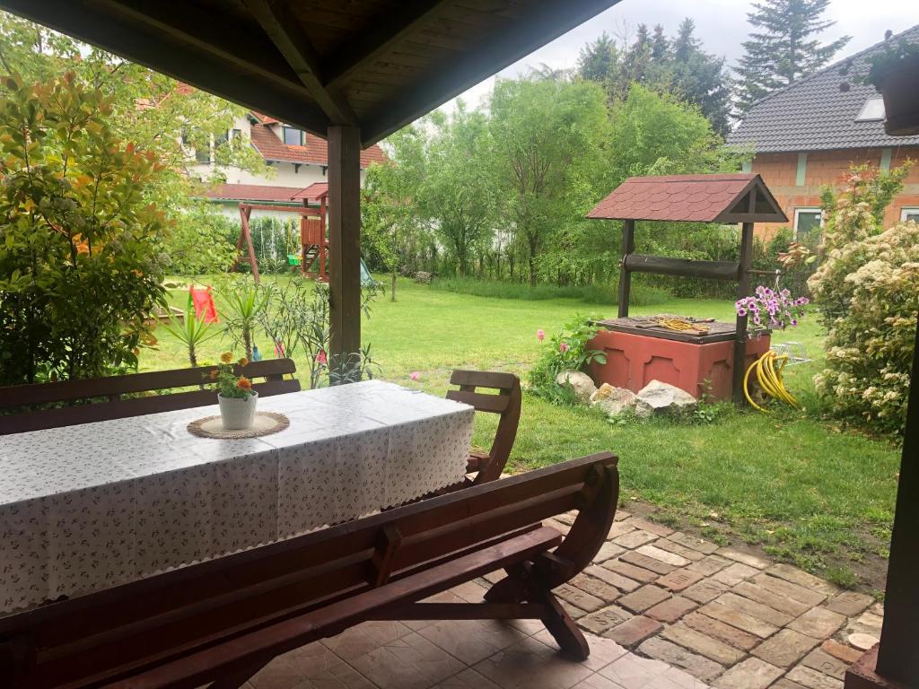 une table et un banc sur une terrasse dans l'établissement Tornácos Vendégház Kápolnásnyék, à Kápolnásnyék