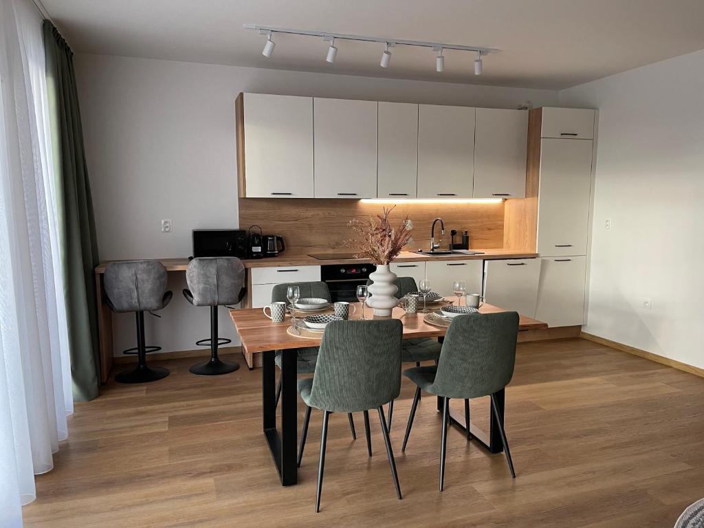 uma cozinha e sala de jantar com mesa e cadeiras em Apartmán Thermal Park 