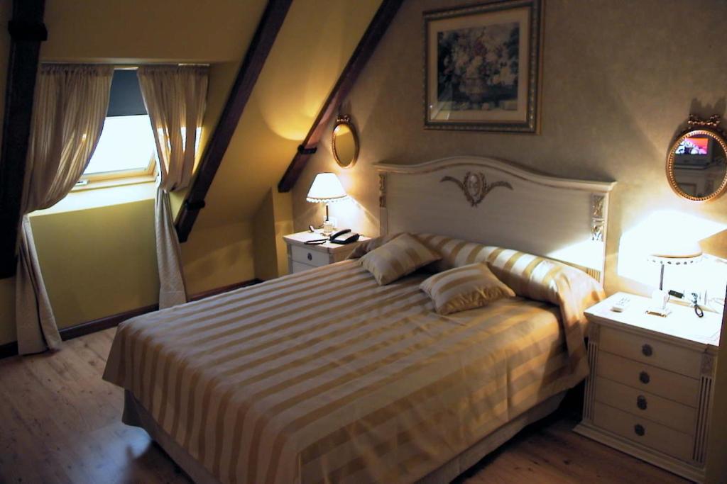 ベナベンテにあるHotel Santiagoのベッドルーム1室(大型ベッド1台、ナイトスタンド2台付)