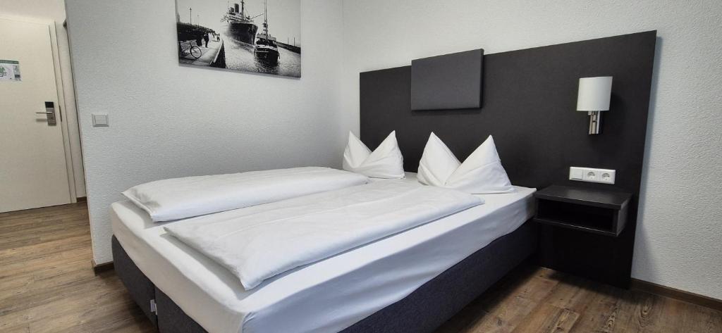 a bedroom with two beds with white sheets at Melvi Hotel Göppingen in Göppingen