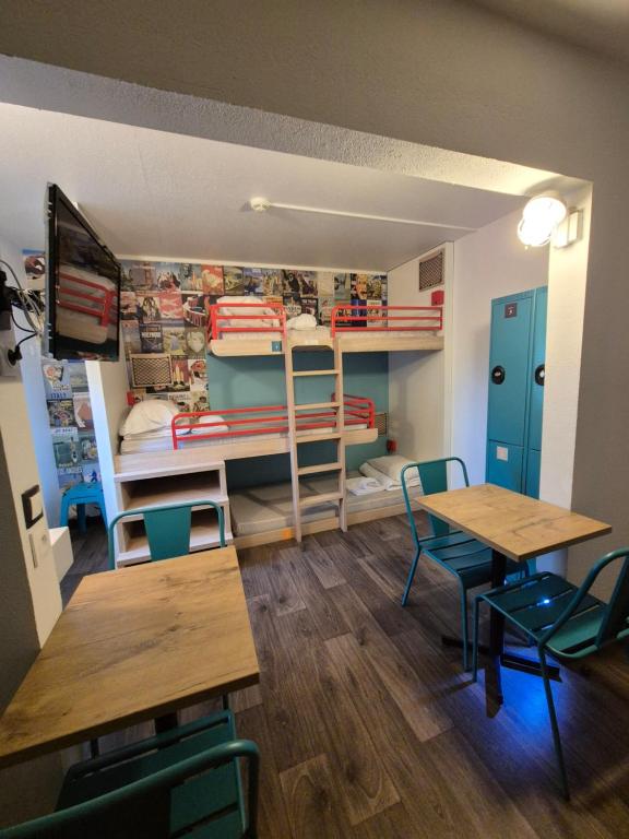 a room with two bunk beds and tables and chairs at hotelF1 Moret Fontainebleau in Moret-sur-Loing