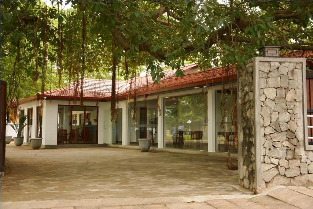 a building with a lot of windows and trees at Trinco Rest House in Trincomalee